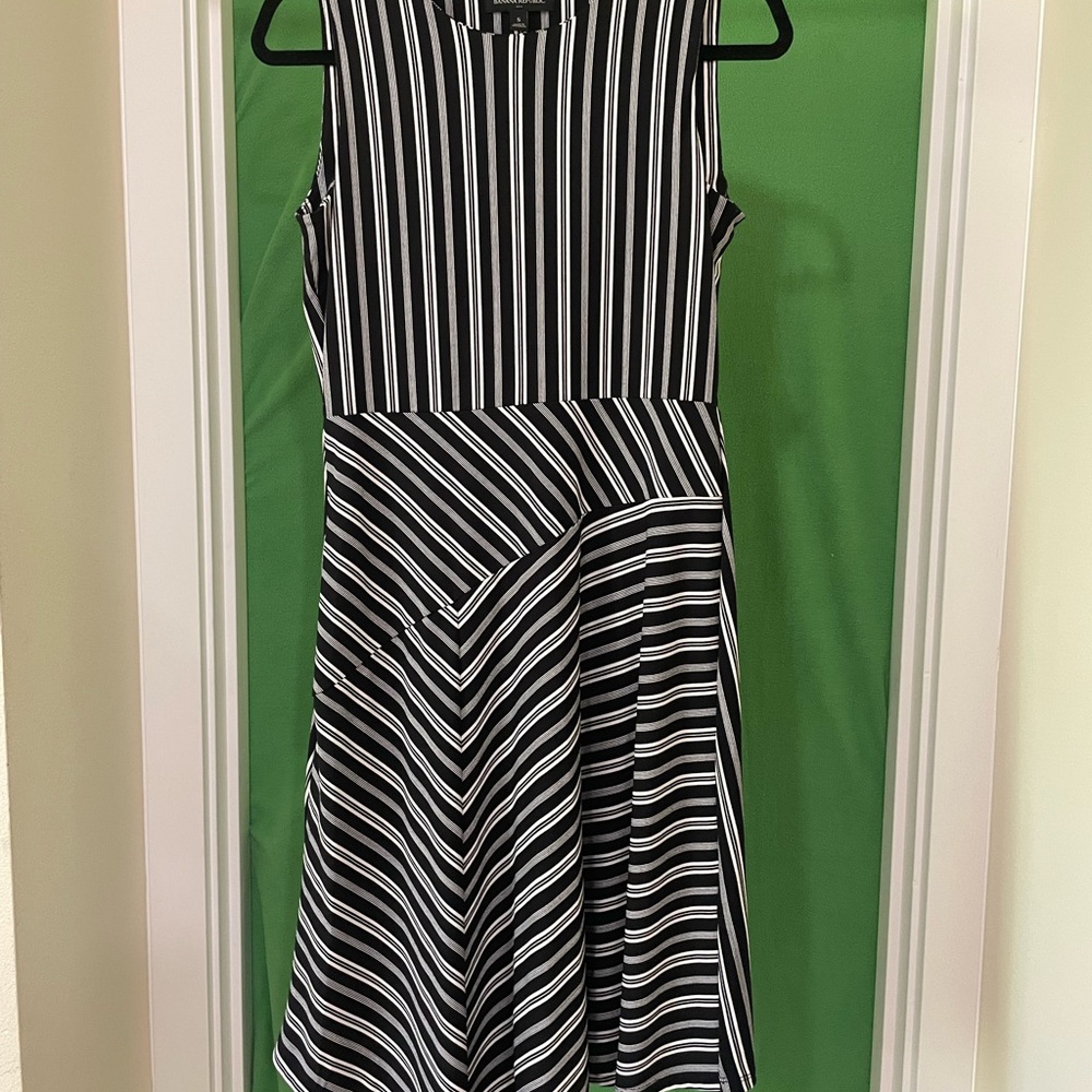 Black and white stripes, sleeveless with asymmetrical bottom. Poly/spandex blend